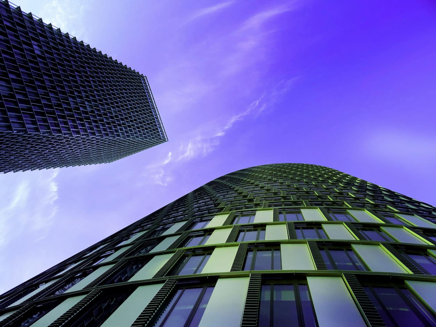 Looking up at two office buildings from the ground